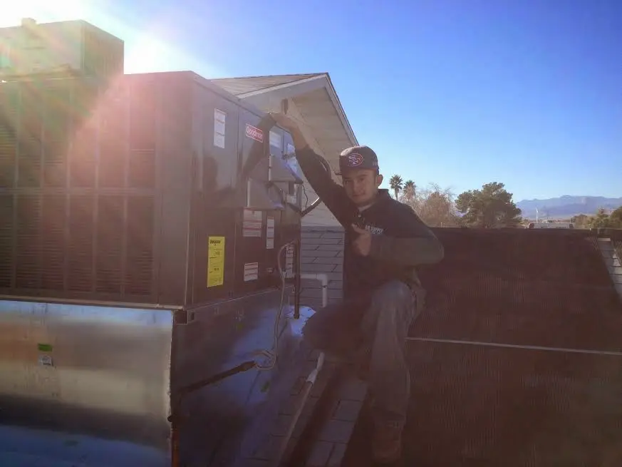 HVAC technician performing Air Duct Repair on a rooftop unit in Cannon